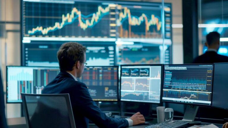 Mann analysiert Finanzdaten auf mehreren Bildschirmen